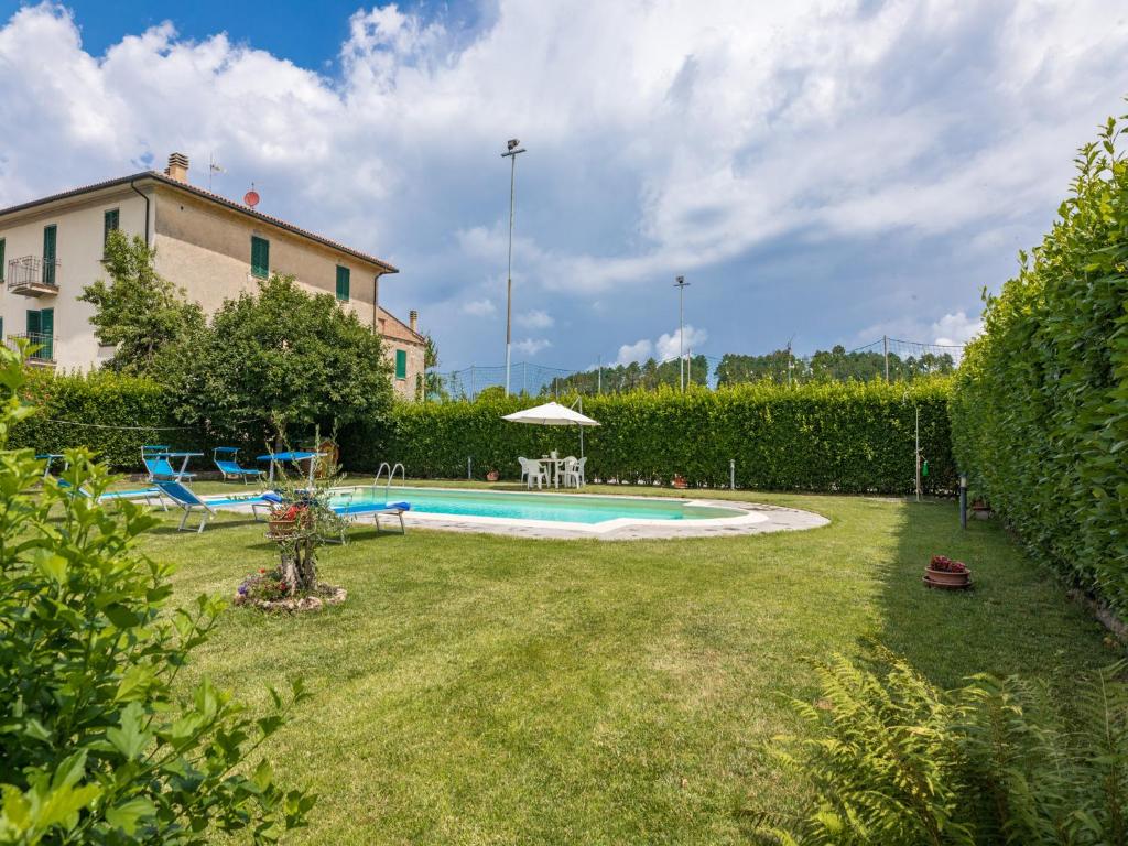 a backyard with a swimming pool and a house at La Pergola in Monticiano