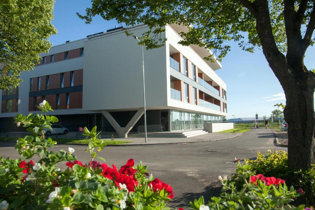 ein Gebäude mit roten Blumen davor in der Unterkunft Riverside Apartment in Pärnu
