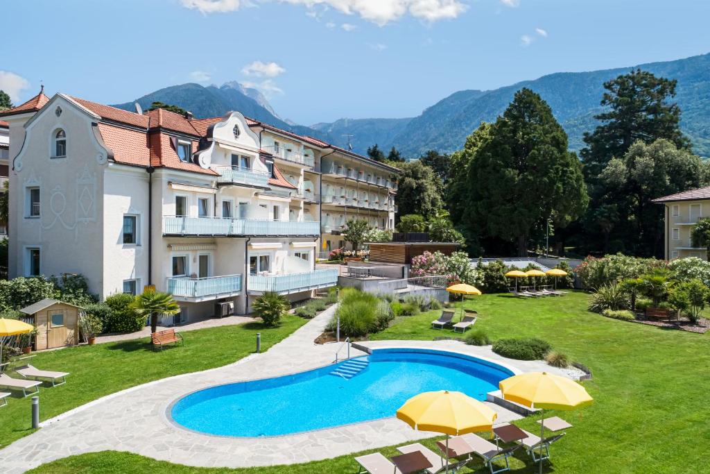 an image of a resort with a swimming pool and umbrellas at Hotel Filipinum in Merano