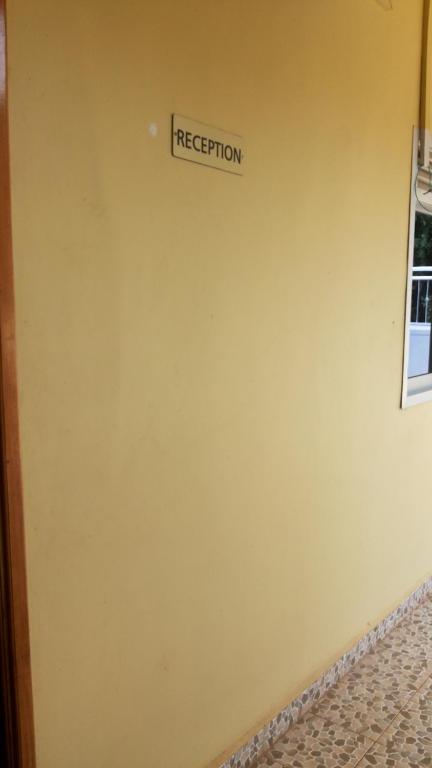 a yellow wall with a rejection sign on it at Hotel Dot Com Entebbe in Entebbe