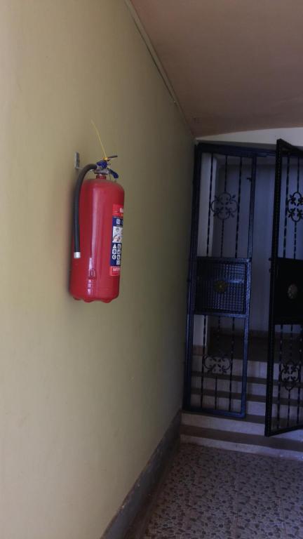 a fire hydrant hanging on a wall next to a door at Hotel Dot Com Entebbe in Entebbe