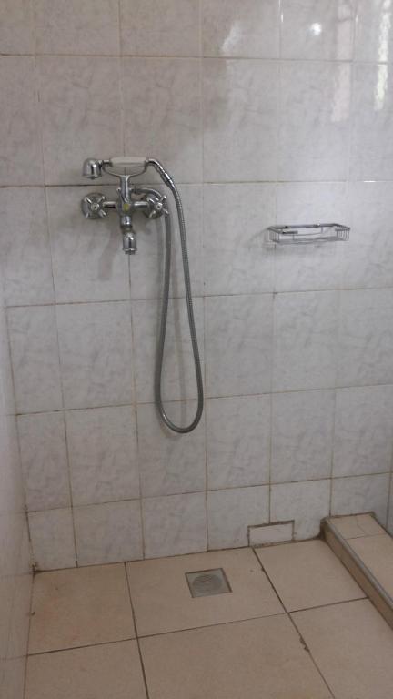 a shower with a hose in a bathroom at Hotel Dot Com Entebbe in Entebbe