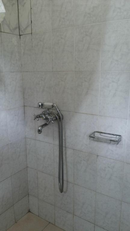 a shower with a shower head in a bathroom at Hotel Dot Com Entebbe in Entebbe