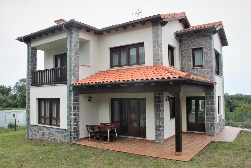 Casa blanca con terraza y mesa en El Limonero de Pría - Casa Vacacional en La Pesa