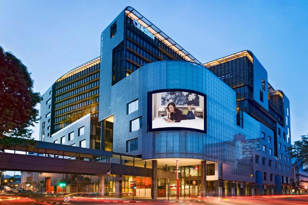a blue building with a picture of a woman on it at Citadines Mount Sophia Singapore in Singapore