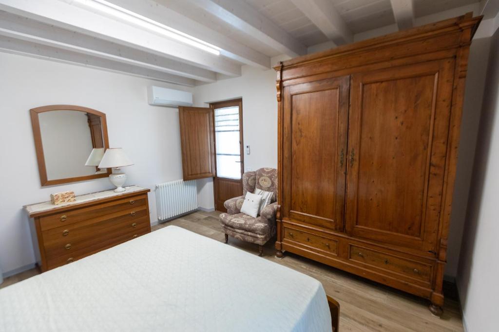 een slaapkamer met een grote houten kast en een stoel bij Vista Lago in Torre del Lago Puccini