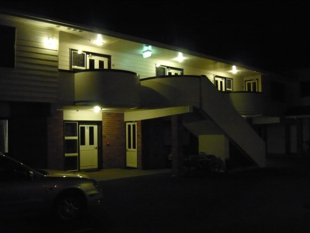 a house with a staircase in front of it at night at Ulster Lodge Motel in Hamilton