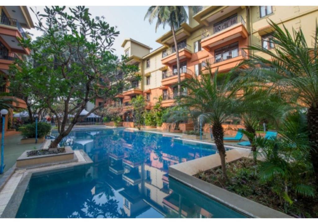 卡蘭古特的住宿－印度尼蘭斯大飯店，一座建筑前的树木游泳池