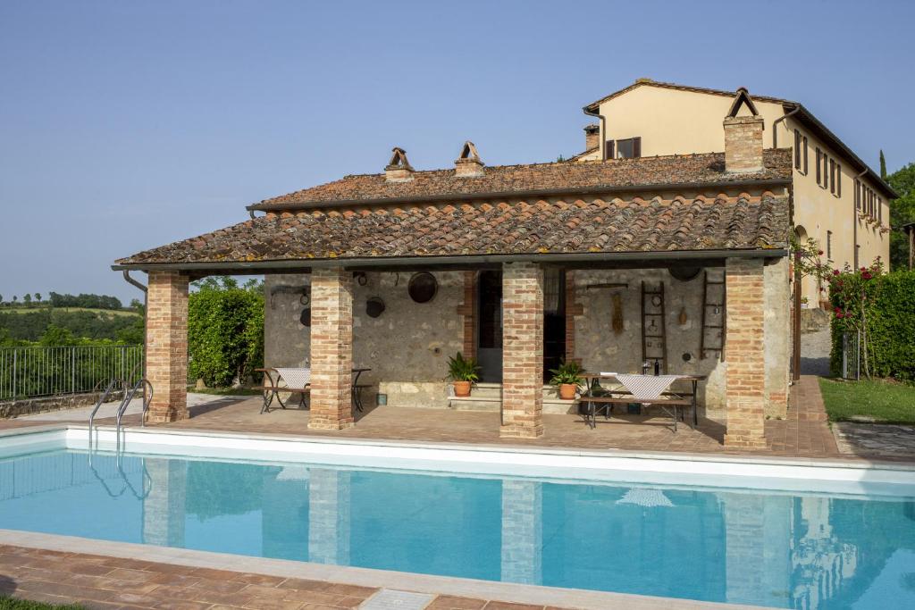 una casa con piscina al lado de un edificio en La Coppa en Asciano