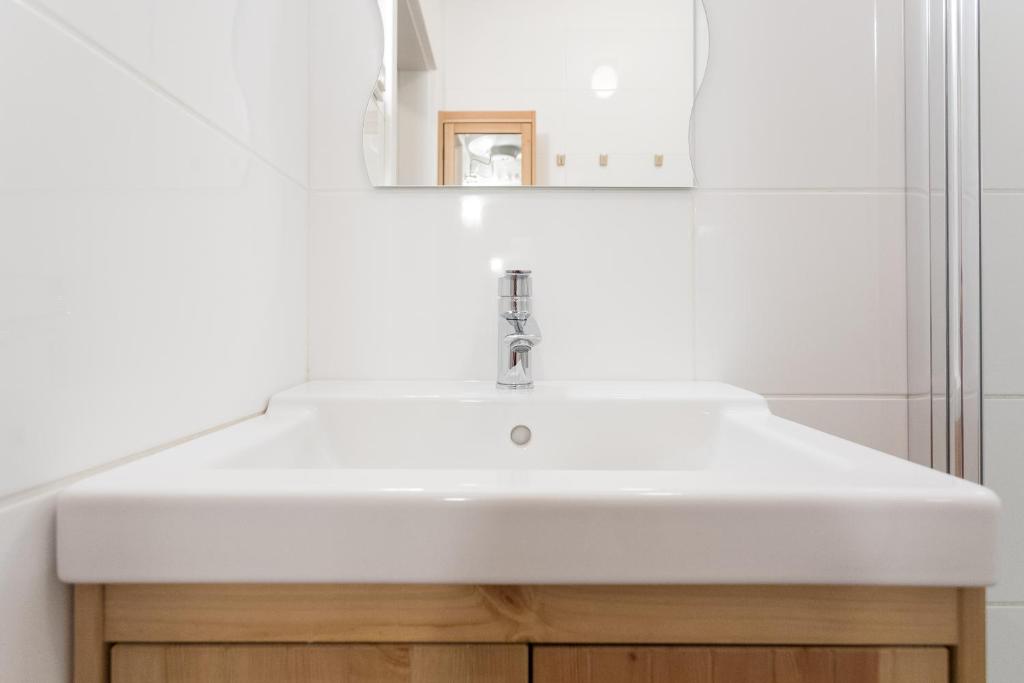 łazienka z białą umywalką i lustrem w obiekcie Vienna Smile Apartment Schoenbrunn w Wiedniu