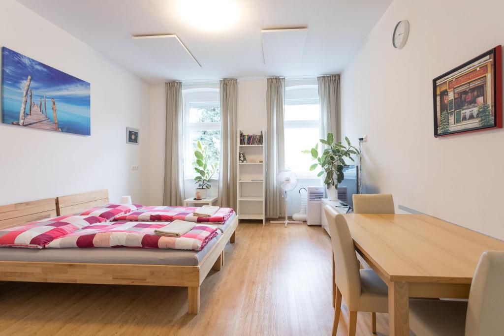 sypialnia z łóżkiem i stołem w obiekcie Vienna Smile Apartment Schoenbrunn w Wiedniu