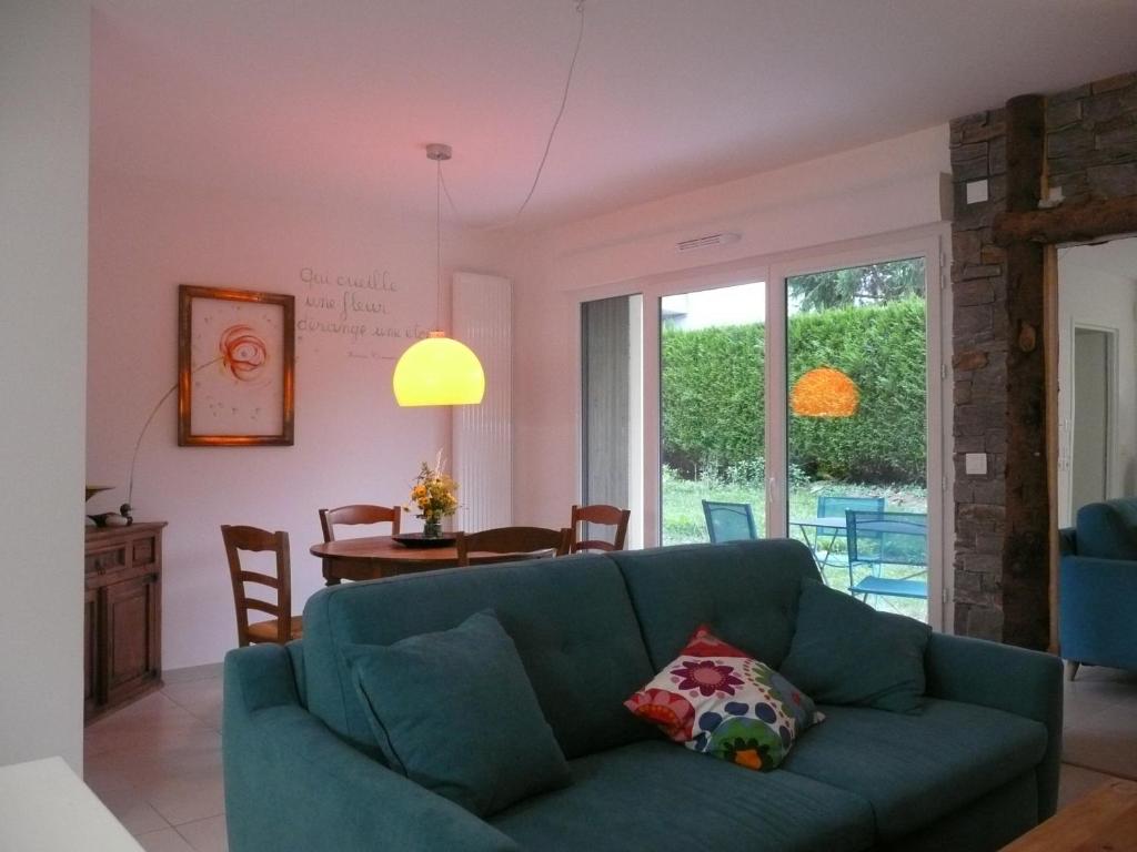 ein Wohnzimmer mit einem blauen Sofa und einem Tisch in der Unterkunft La Porte du Paradis in Doussard