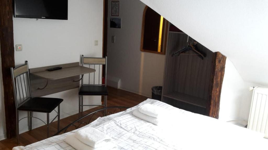 a bedroom with a bed and a table and chairs at Pension Zentrum Riesa in Riesa