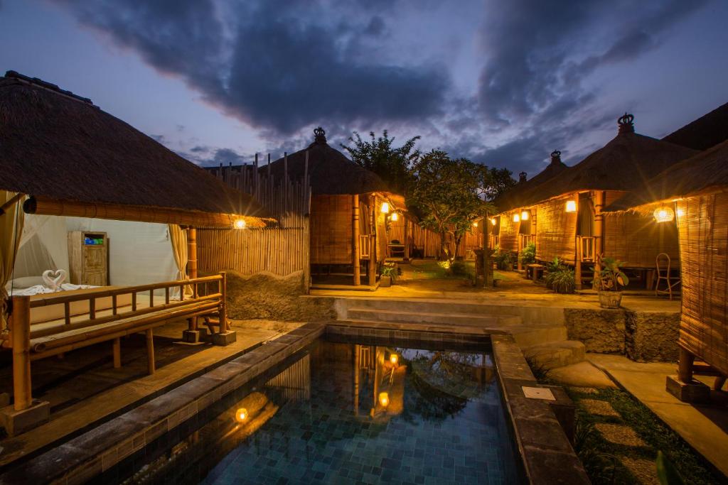 un cortile con piscina e una casa di Salty Shakas Bamboo Stay Canggu a Canggu
