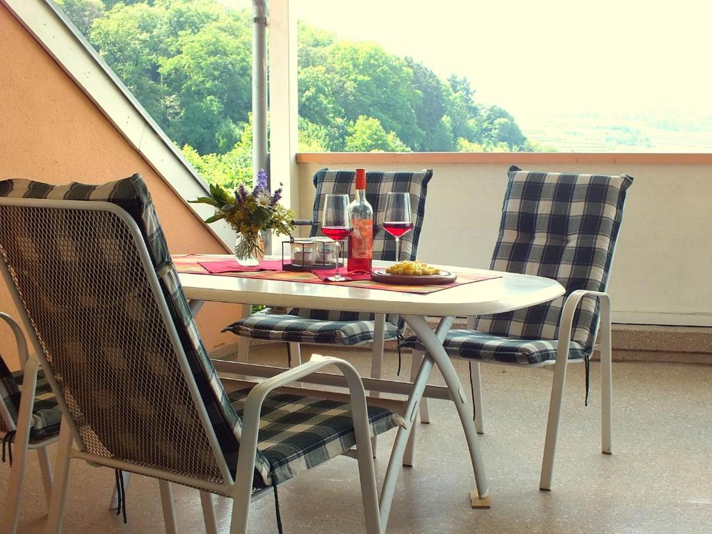 einen Tisch mit einem Teller Essen und einer Flasche Wein in der Unterkunft Ferienwohnung Schnee in Bischoffingen