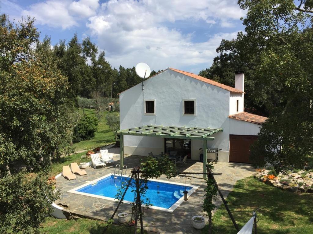 a house with a swimming pool in front of it at Casa dos Cavalos in Sertã