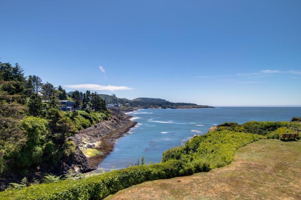 a view of the ocean from a hill with trees at Whale-come Home in Depoe Bay