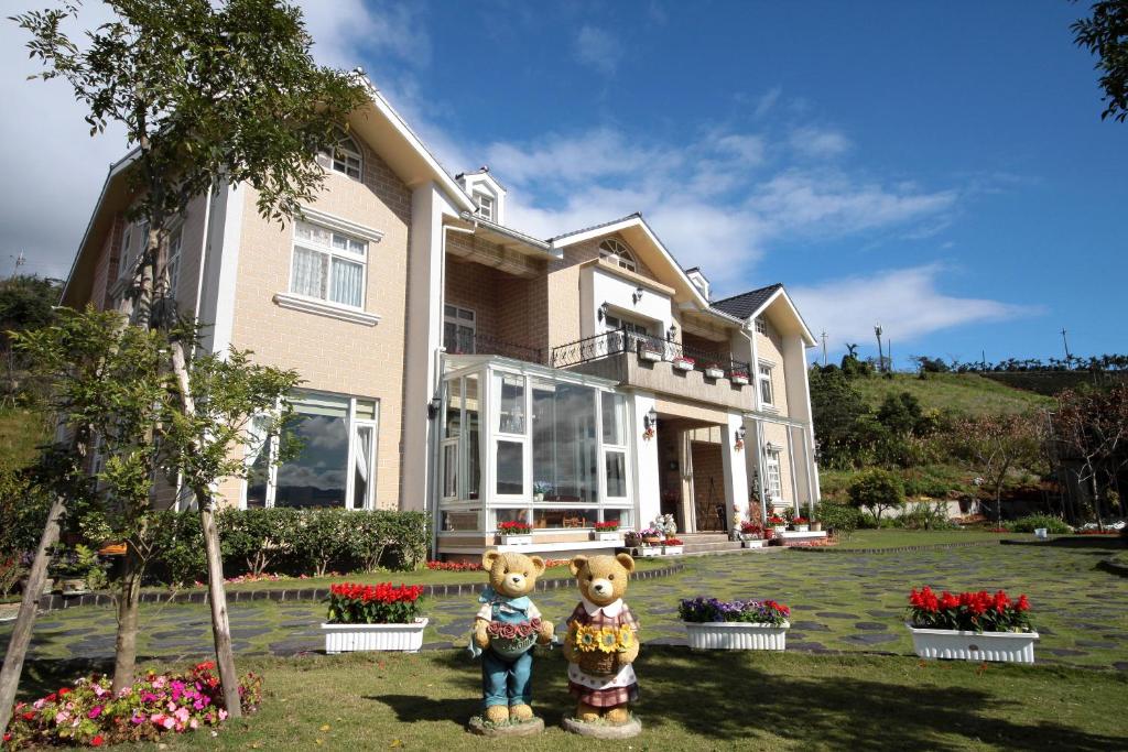 Zwei Teddybären stehen vor einem Haus in der Unterkunft Yilan Ya Lu Homestay in Datong
