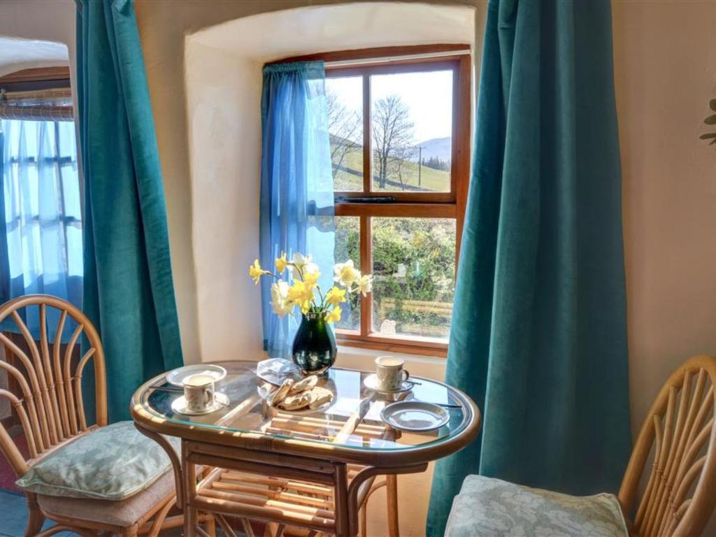 TrawsfynyddにあるHoliday Home Llyn view cottage by Interhomeの窓のある部屋(テーブル、椅子付)