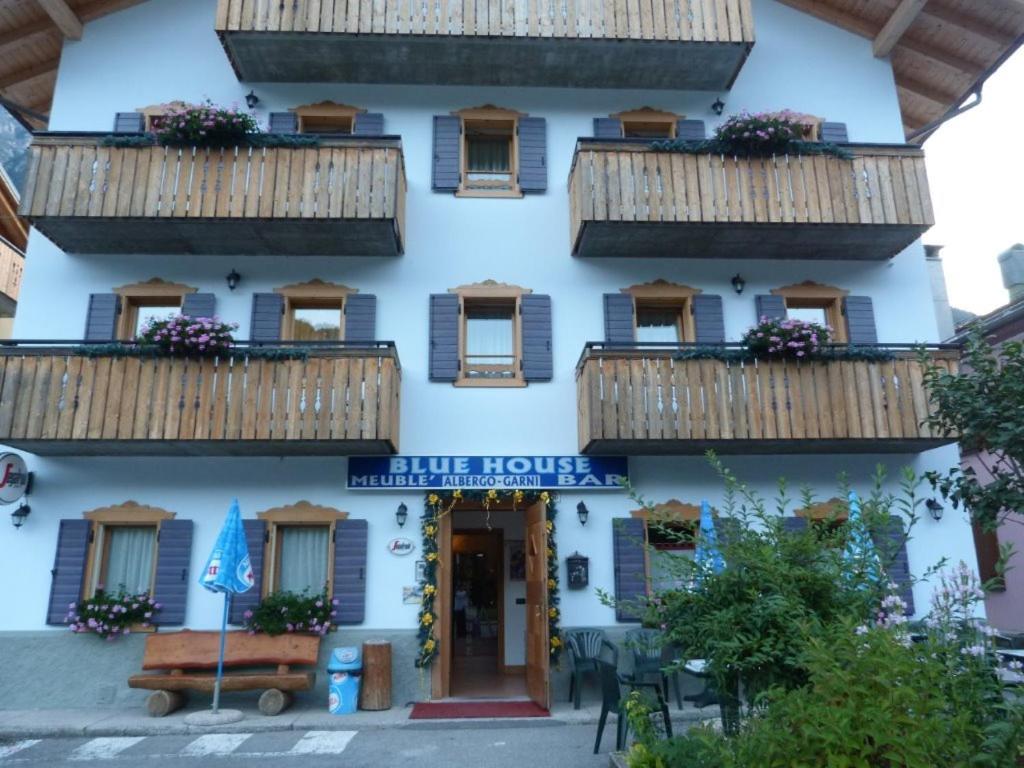 un edificio con ventanas azules y balcones de madera en Meublè Blue House en Auronzo di Cadore