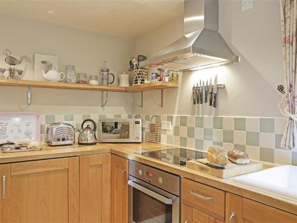 a kitchen with a stove and a microwave at Holiday Home Little Glebe by Interhome in Middleton