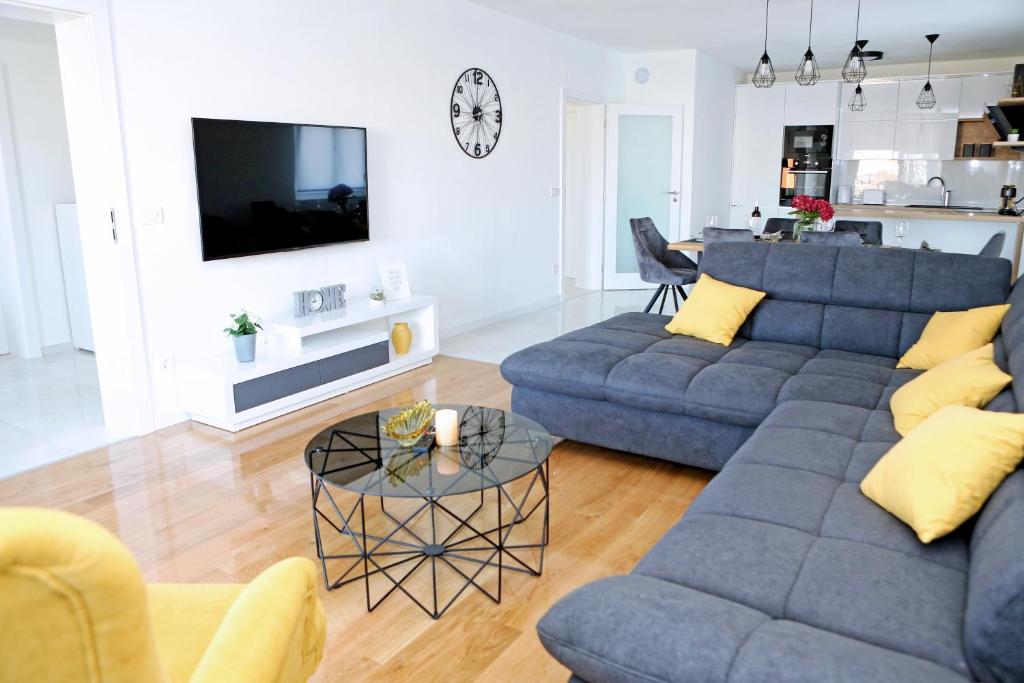 sala de estar con sofá azul y mesa en Apartment Villa Grga, en Zadar