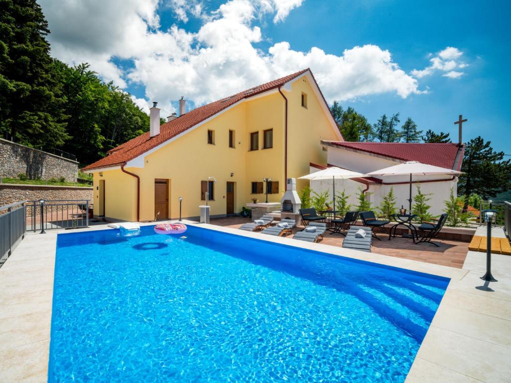 a villa with a swimming pool in front of a house at Apartment Oltari-3 by Interhome in Biljevine
