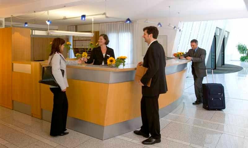 eine Gruppe von Personen, die an einem Schalter auf einem Flughafen stehen in der Unterkunft GenoHotel Karlsruhe in Karlsruhe