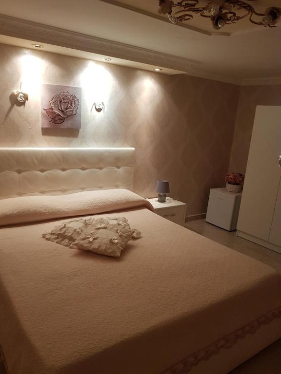 una camera da letto con un letto con lenzuola bianche e fiori sul muro di Melissa a Toledo a Napoli