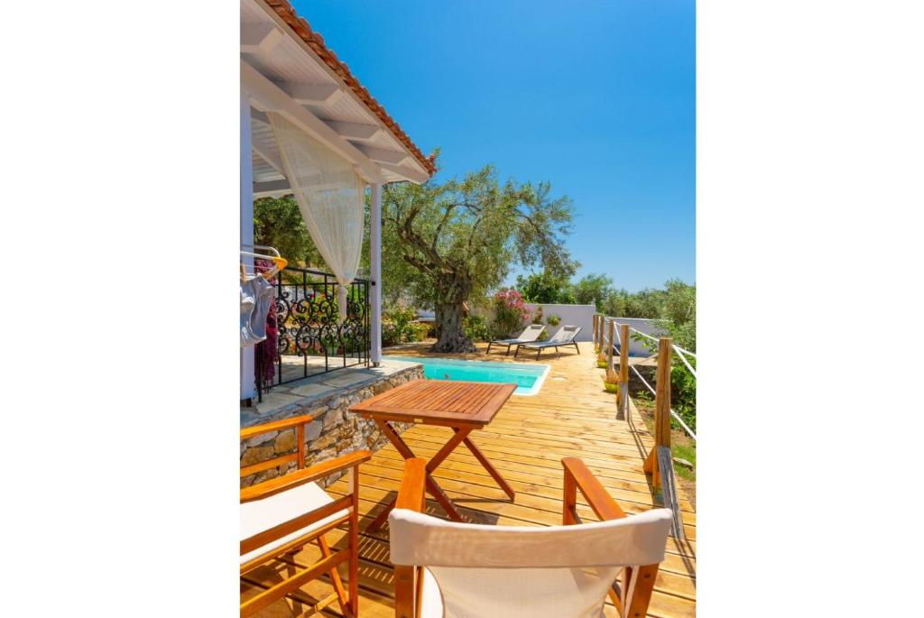 a deck with a table and chairs next to a swimming pool at Neptune in Alonnisos