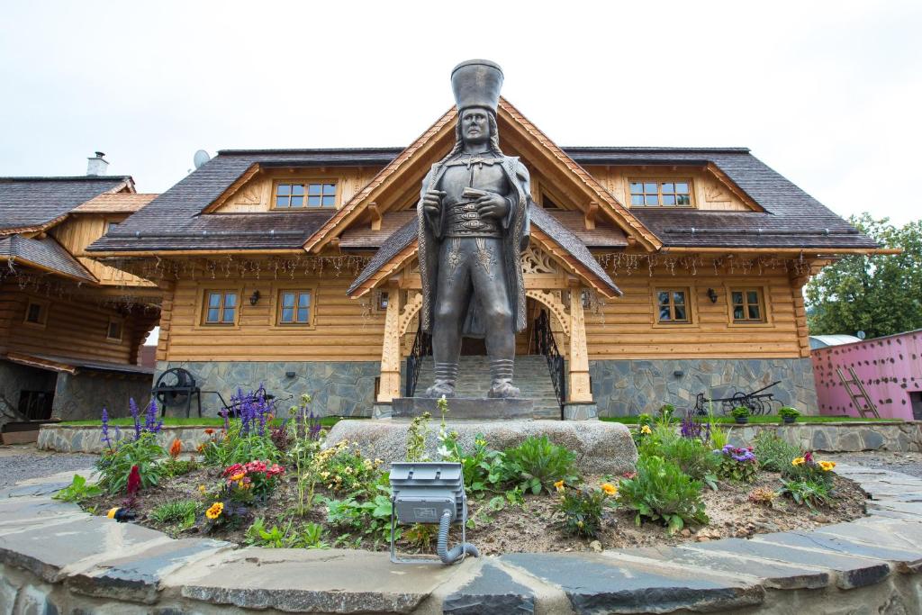a statue of a woman in front of a building at Zbojnicky penzion in Oravska Jasenica