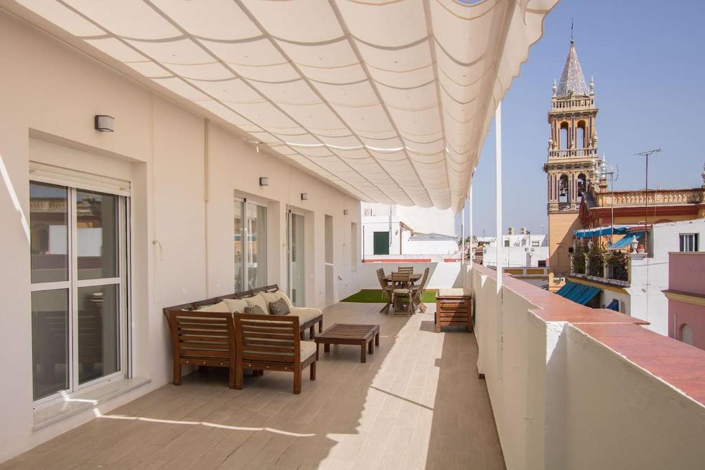 un balcón con sillas y una mesa y un edificio en Triana Deluxe Skyview, en Sevilla