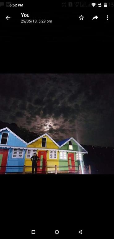 a person standing in front of a colorful house at Rainbow Valley Resort in Sonāda