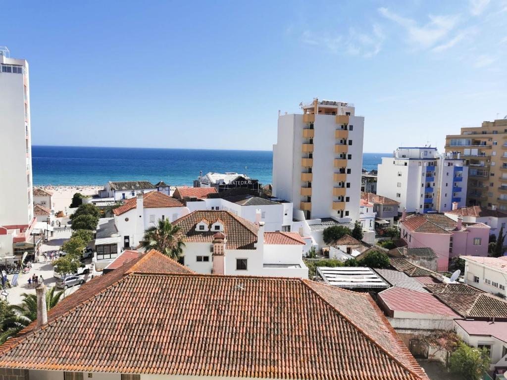 vistas a una ciudad con edificios y al océano en Apartamento Praia Rocha Vista Mar Ambar en Portimão