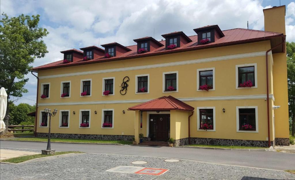een groot geel gebouw met een rood dak bij Penzión Altmayer in Banská Štiavnica