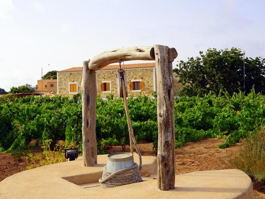 uma estrutura de madeira com um balde e um baloiço em Casa Can Pep - Astbury Formentera em Sant Ferran de Ses Roques