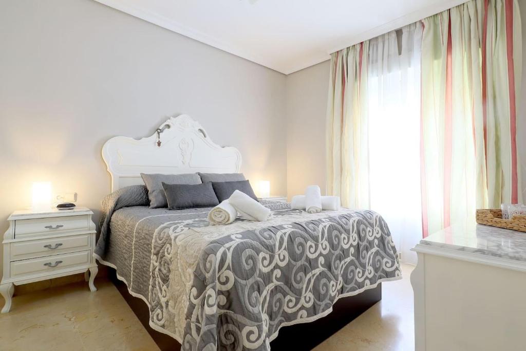 a bedroom with a bed with a white bedspread and a window at Duque de Hornachuelos, parking en pleno centro in Córdoba
