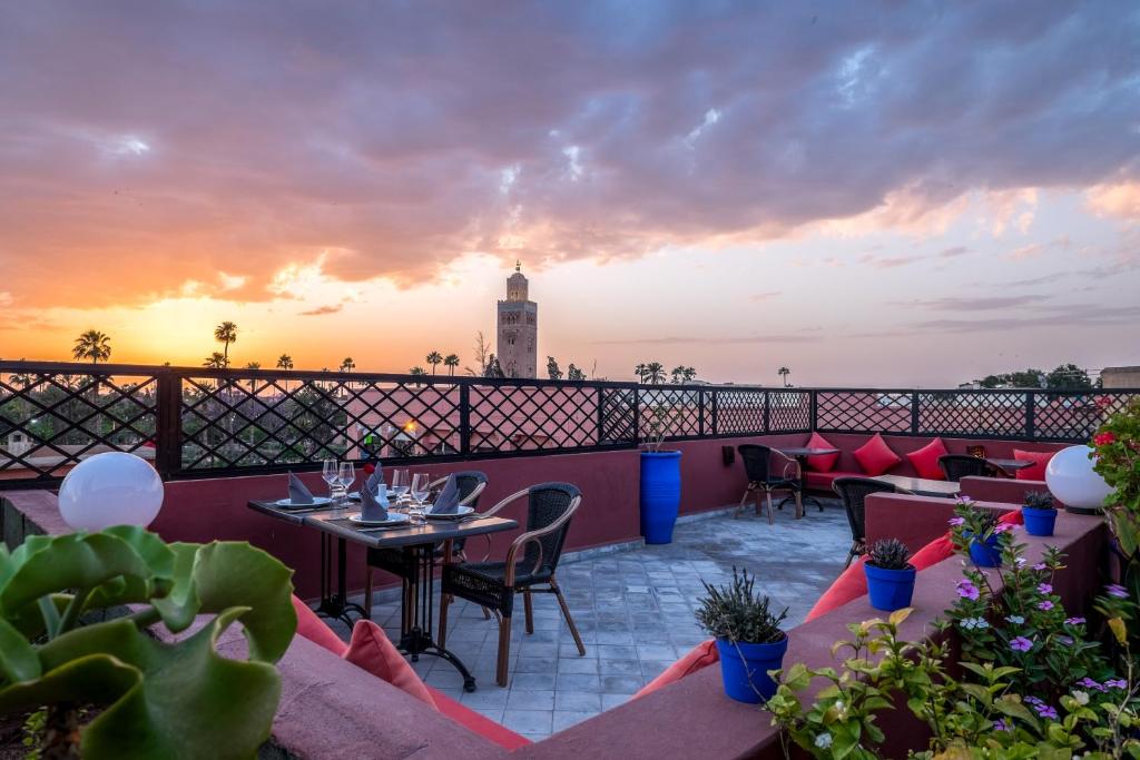 un toit-terrasse avec des tables et des chaises ainsi qu'un phare dans l'établissement Riad Marrakech By Hivernage, à Marrakech