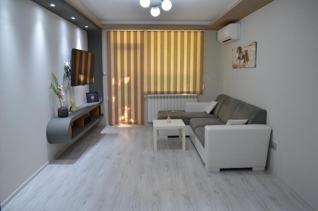 Luxury Apartment near Varna, located in Targovishte في تارغوفيشته: غرفة معيشة مع أريكة وطاولة