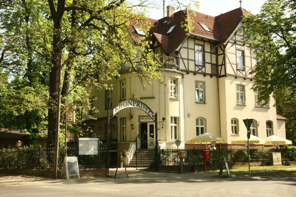 a large white building with a brown roof at Hotel Kronprinz in Falkensee