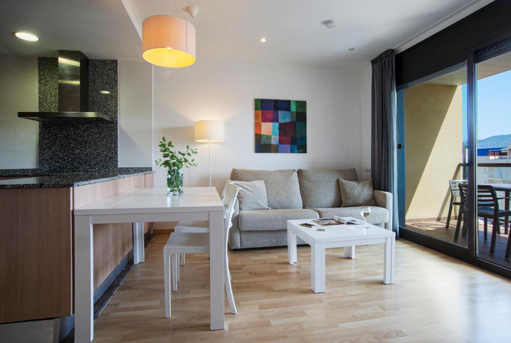 a kitchen and living room with a table and a couch at Pierre & Vacances Empuriabrava Marina in Empuriabrava