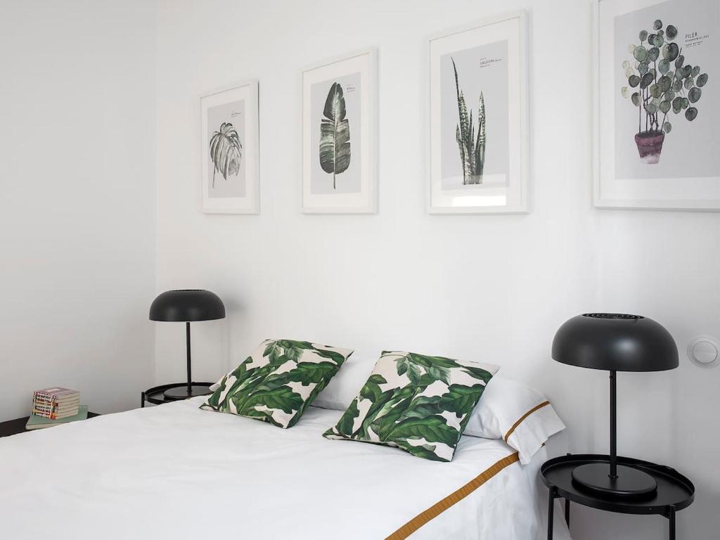 ein Schlafzimmer mit einem weißen Bett und zwei schwarzen Stühlen in der Unterkunft Casa Antica by Valcambre in Sevilla