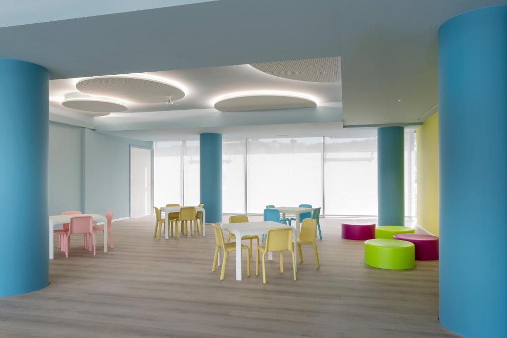 a room with tables and chairs in a building at YOUMAMI Suite Hotel Wellness&Spa in Giulianova