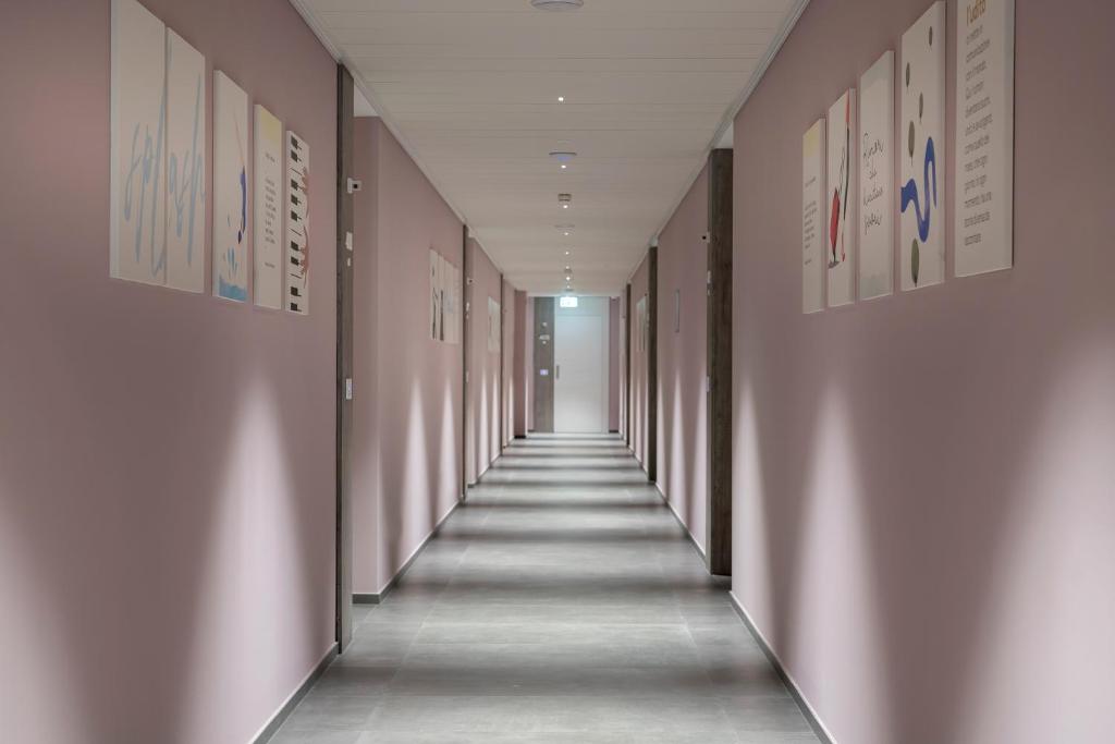 a hallway of an office building with pink walls at YOUMAMI Suite Hotel Wellness&Spa in Giulianova