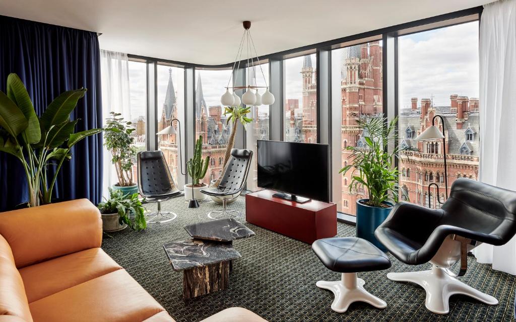 a living room filled with furniture and a large window at The Standard London in London
