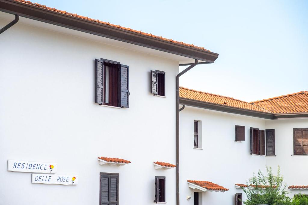 une maison blanche avec un panneau sur son côté dans l'établissement Delle Rose, à Cavallino-Treporti