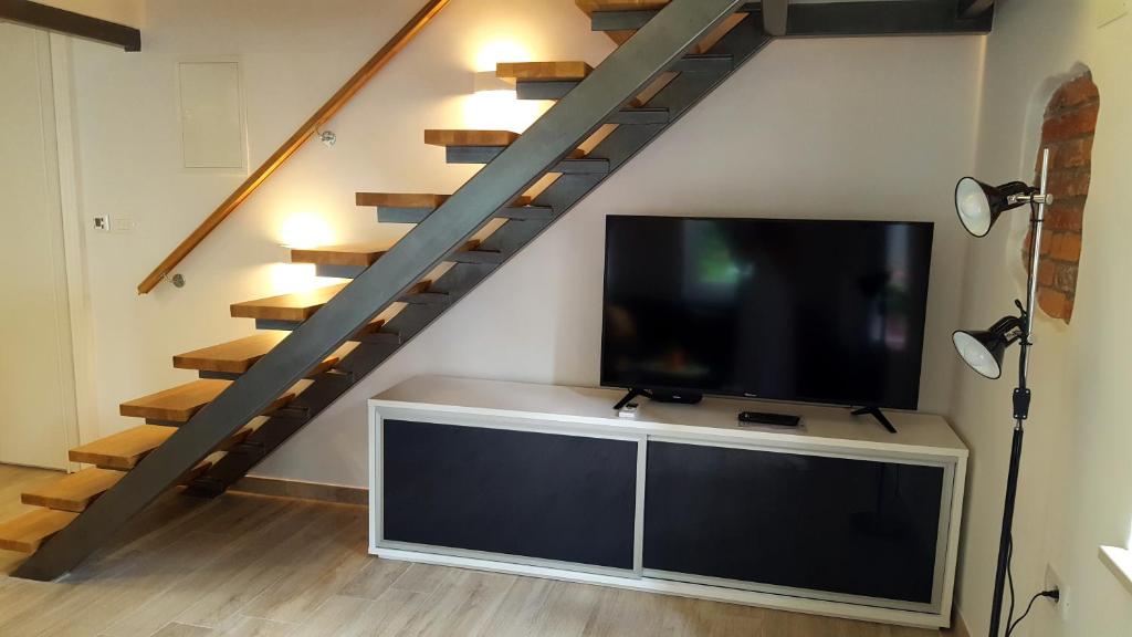 salon z telewizorem z płaskim ekranem i schodami w obiekcie Studio Apartment Vanna - 1st row to the sea w mieście Opatija