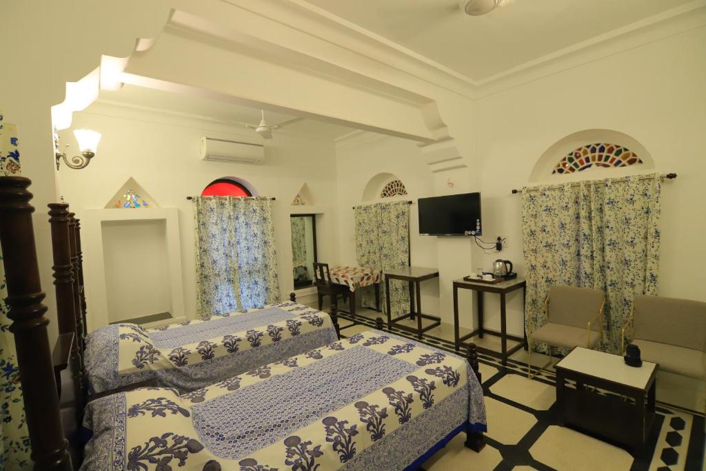 Chanod Haveli في جودبور: غرفة نوم فيها سرير وتلفزيون