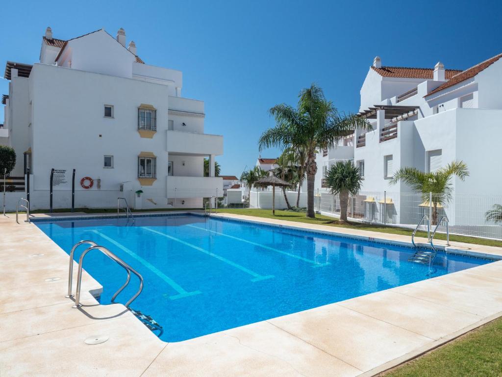 a swimming pool in front of a building at 2060-Newly furnished 2 bedrooms apt with golf in Estepona
