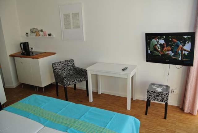 - une chambre avec une table, une télévision et un bureau dans l'établissement Seehütte Ferienwohnung 304, à Cuxhaven